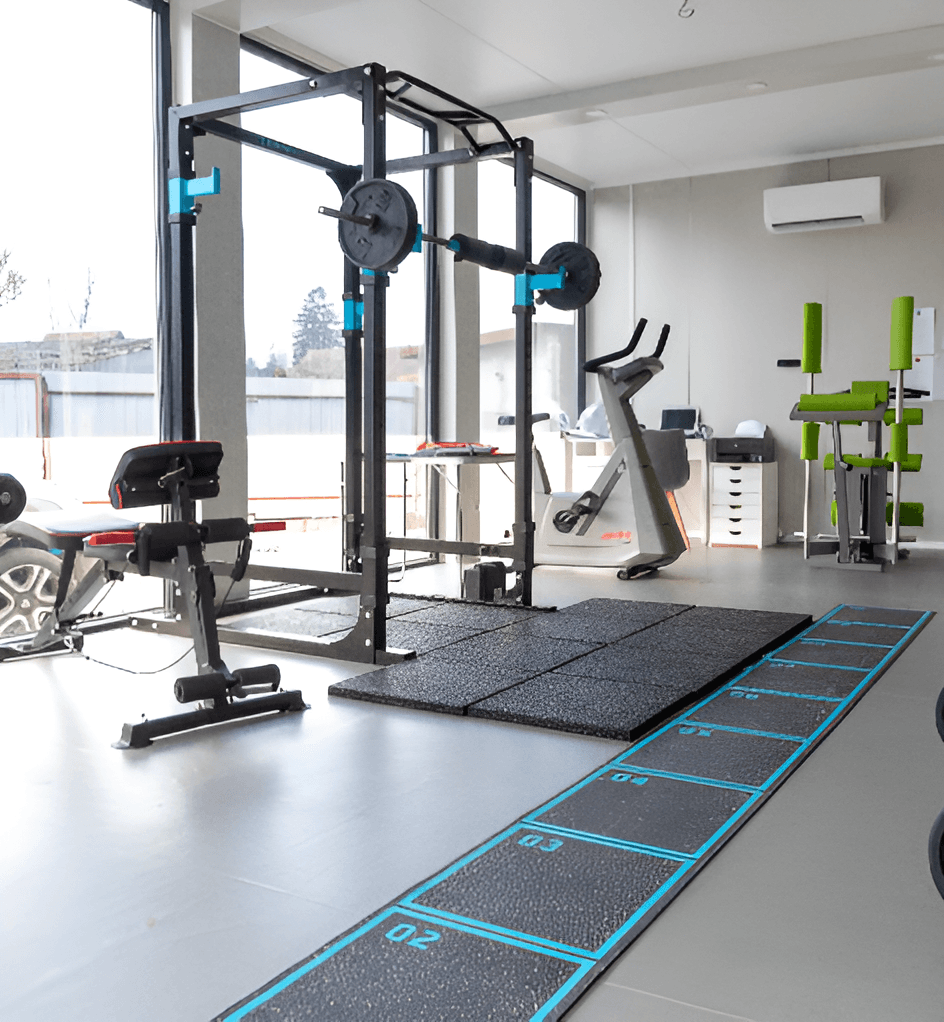 Sala de kinetoterapie FIZIONOVA, cu aparate de forță și zonă de exerciții funcționale.